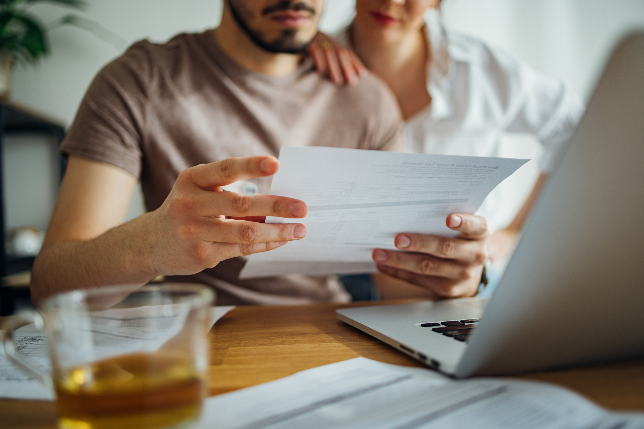 Couple look worried as they look at inheritance tax document in close-up photoshoot.