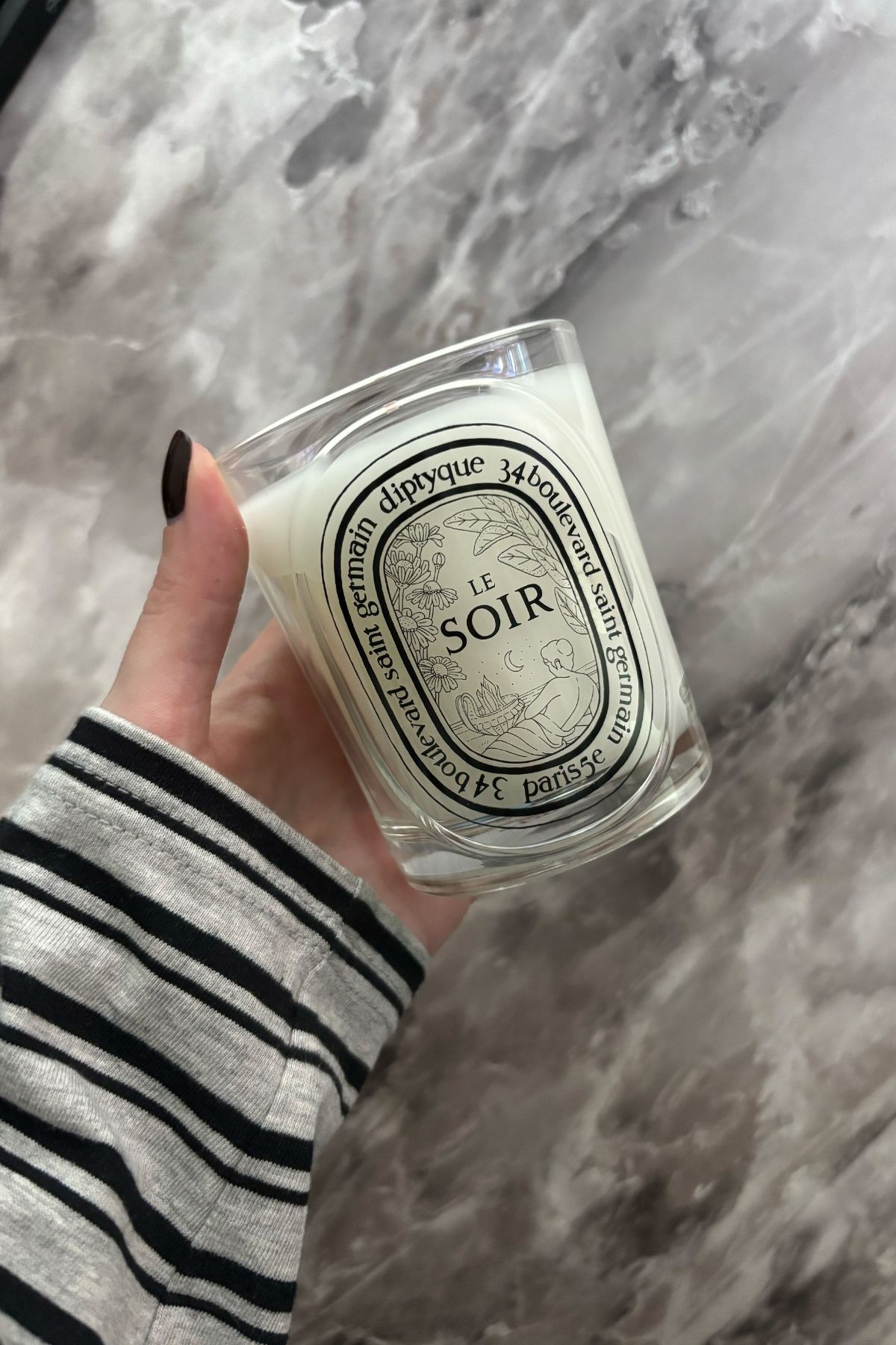 Deputy beauty editor Grace Lindsay holding the Diptyque Le Soir candle