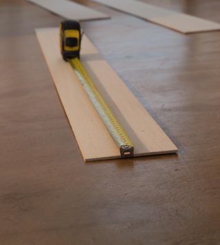 A tape measure measuring a plank of wood