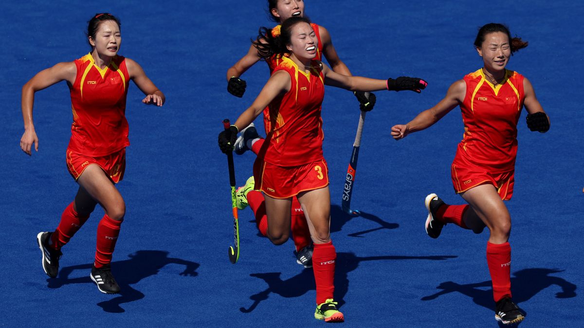 The Chinese women&#039;s hockey team, in red shorts, socks and vests, celebrate victory at the 2024 Paris Olympic Games.