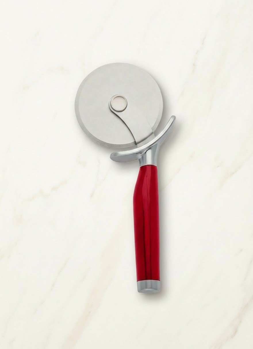 Red KitchenAid accessory on cream marble background
