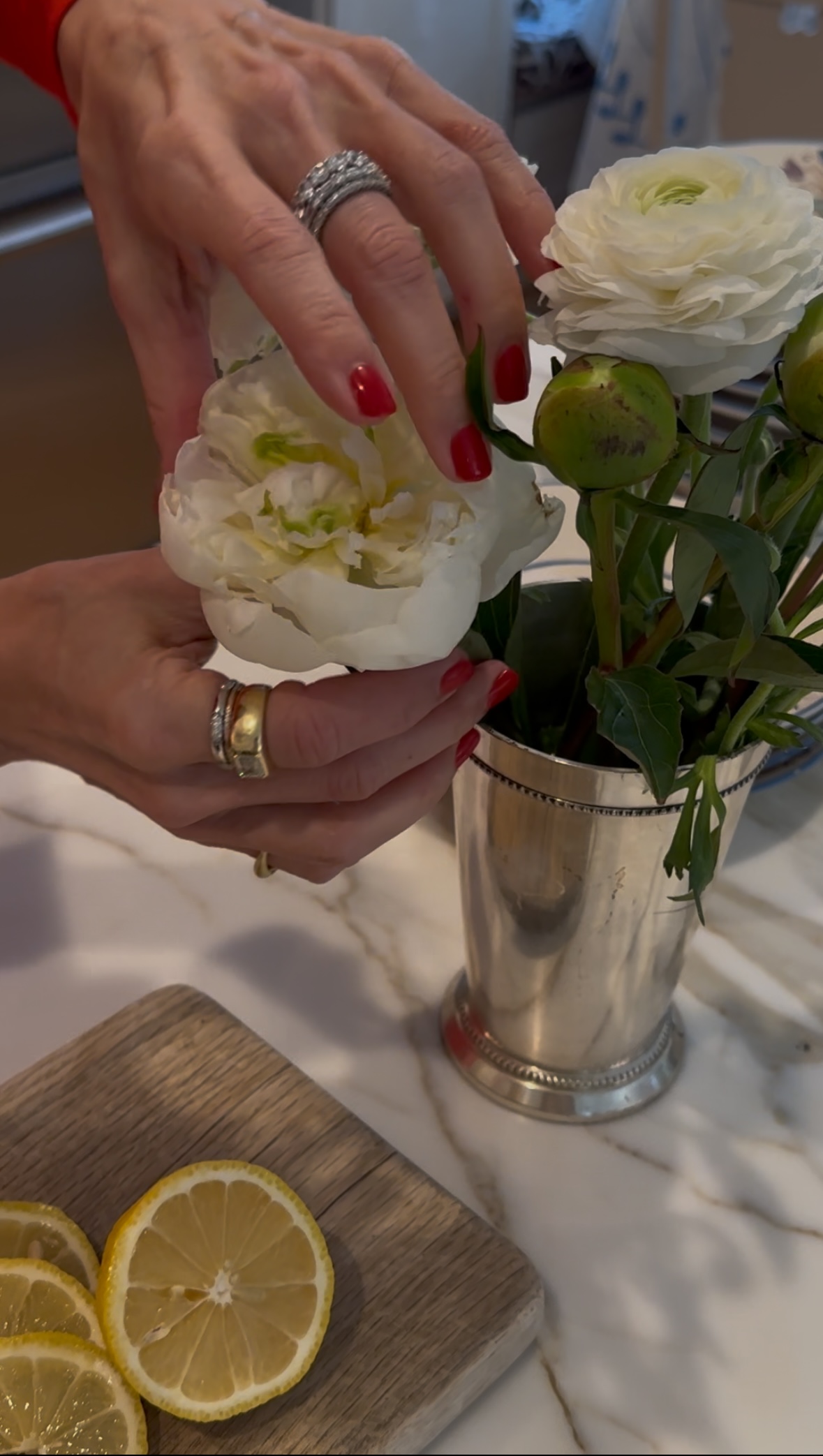 a close-up image of Larissa Mills wearing a stack of silver and gold rings