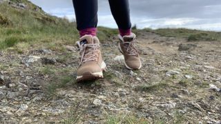 Hiker's feet on the trail wearing tan boots