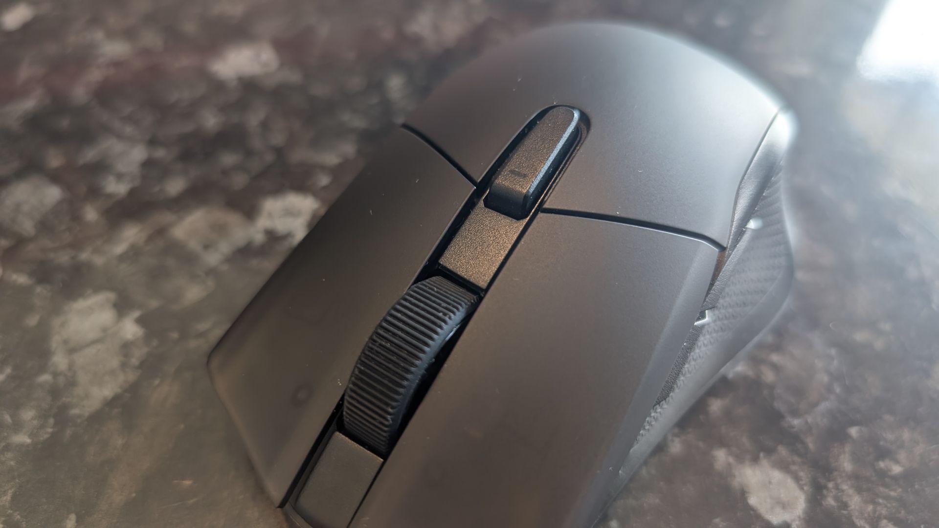 The Corsair Harpoon V2 Wireless gaming mouse pictured on a dark marble worktop.