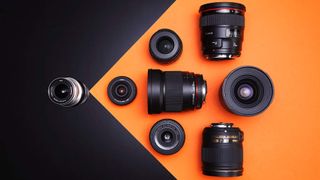 A selection of wide-angle prime lenses on an orange and black background