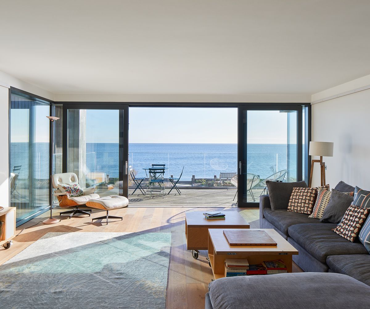 Living room with triple-glazed sliding doors overlooking a sea view