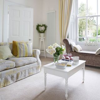 living room with sofa white and pale yellow yo yo striped cotton cushions fabrics and curtains