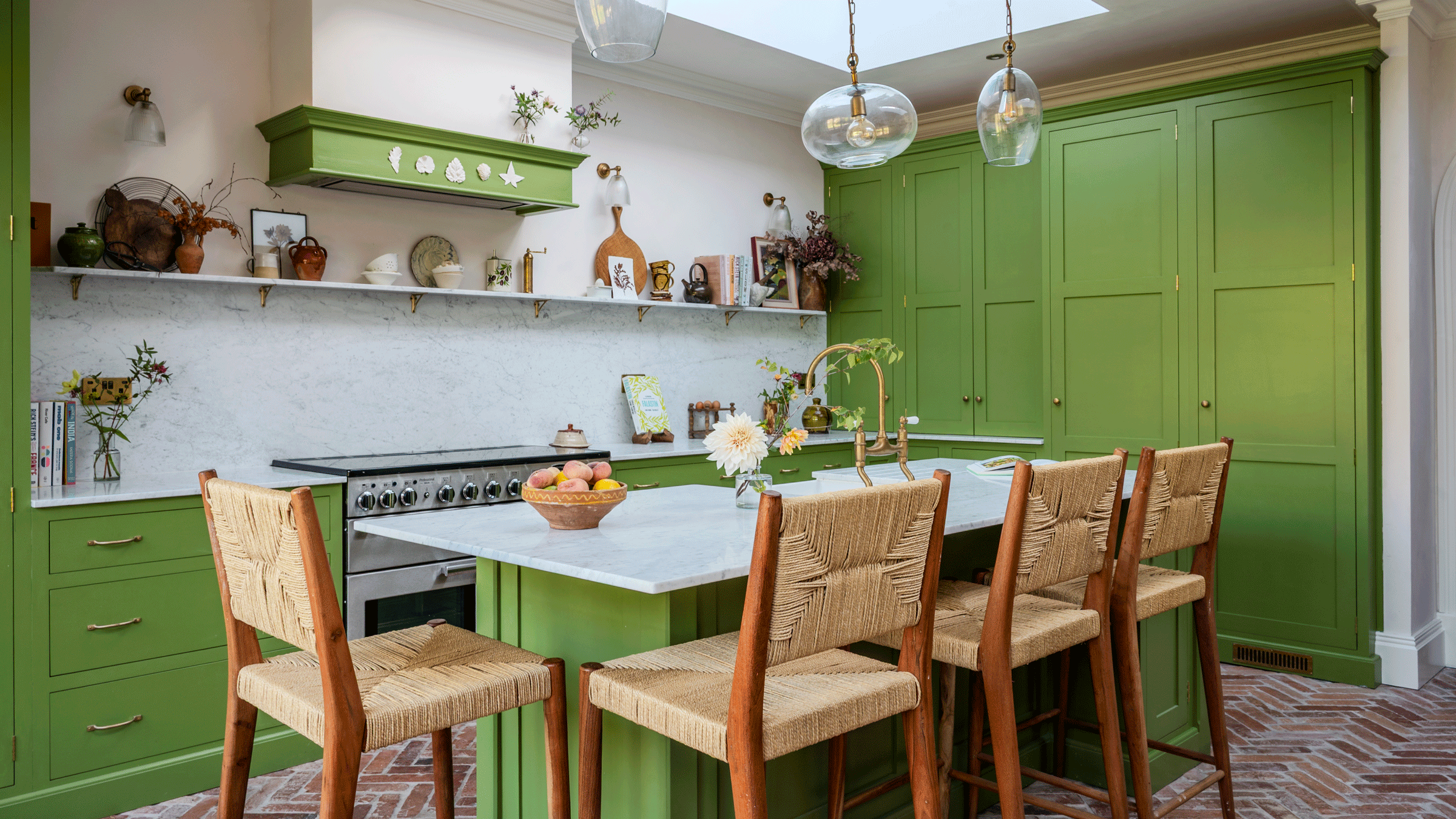 a green shaker kitchen with open shelving and herringbone flooring, a large kitchen island with breakfast bar and four bar stools