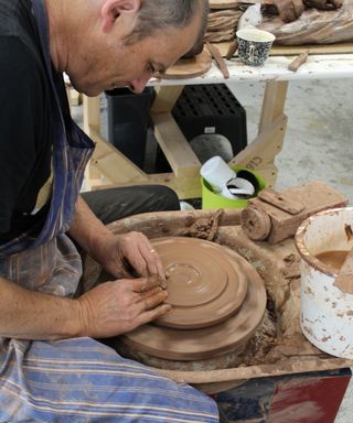 Porta Romana craftsman making lampbase on potter's wheel