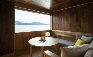seating area with wooden decor looking out window to water and mountains