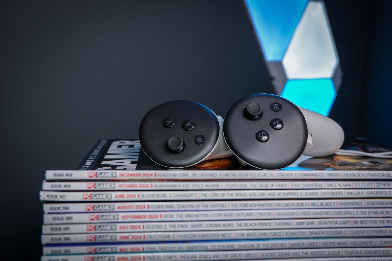 A Meta Quest 3S, alongside a Quest 3 and Quest 2, on a stack of PC Gamer magazine.