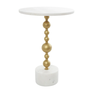 A white marble side table with a gold geometric stem