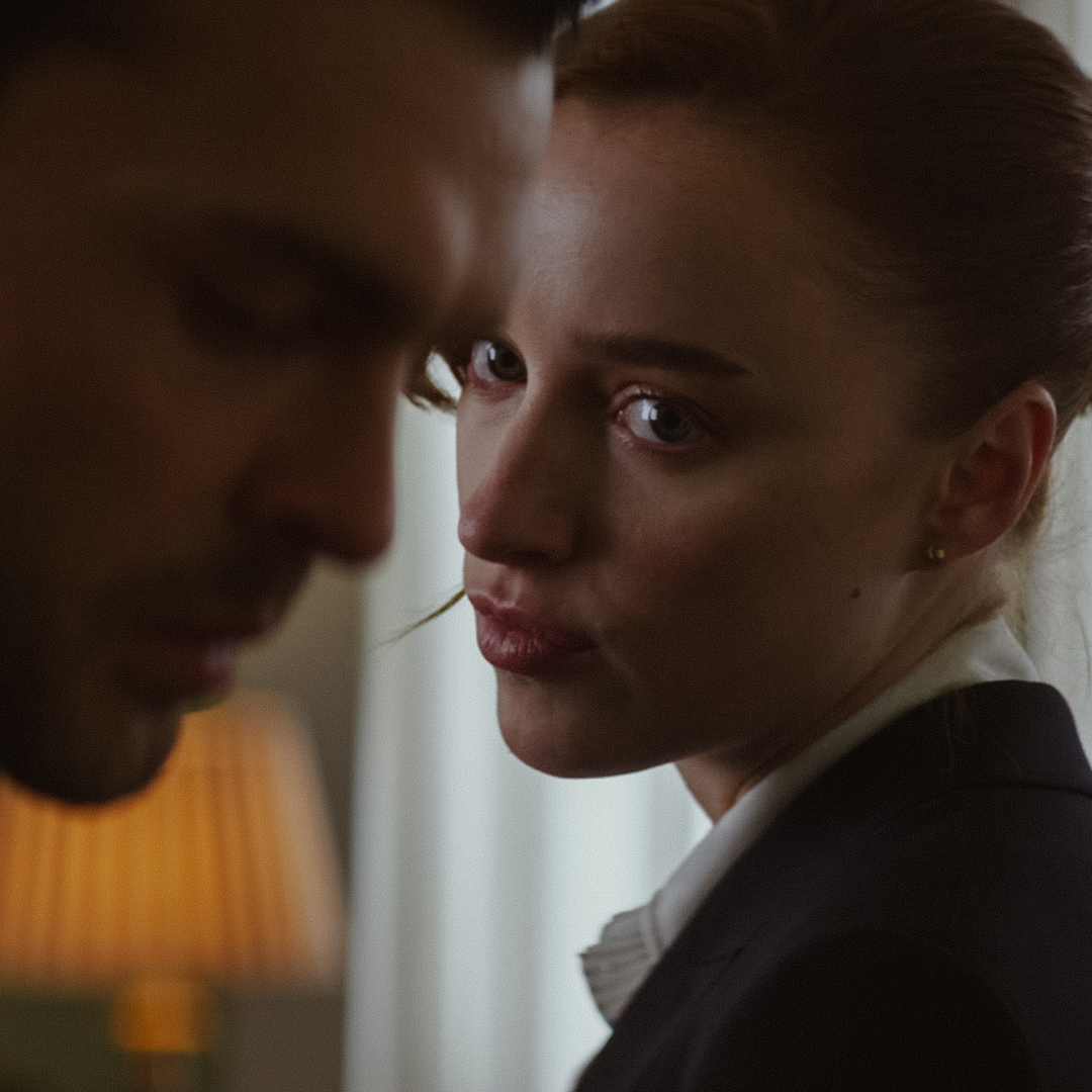 phoebe dynevor looks over her shoulder at alden Ehrenreich in a still from the movie fair play
