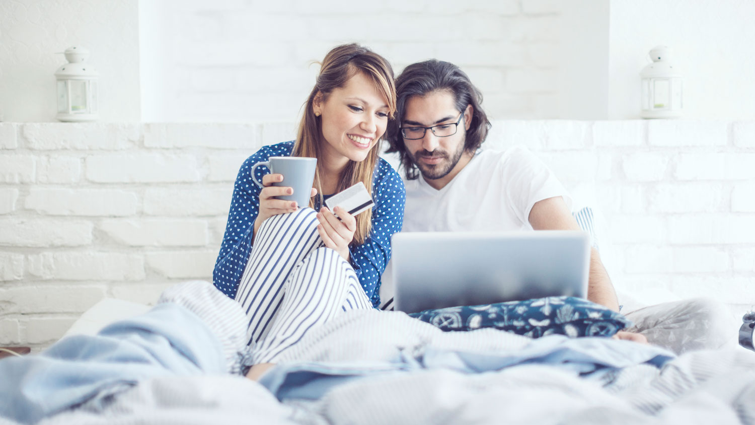 A couple in bed, shopping online