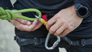 Man setting up climbing harness while wearing sports watch