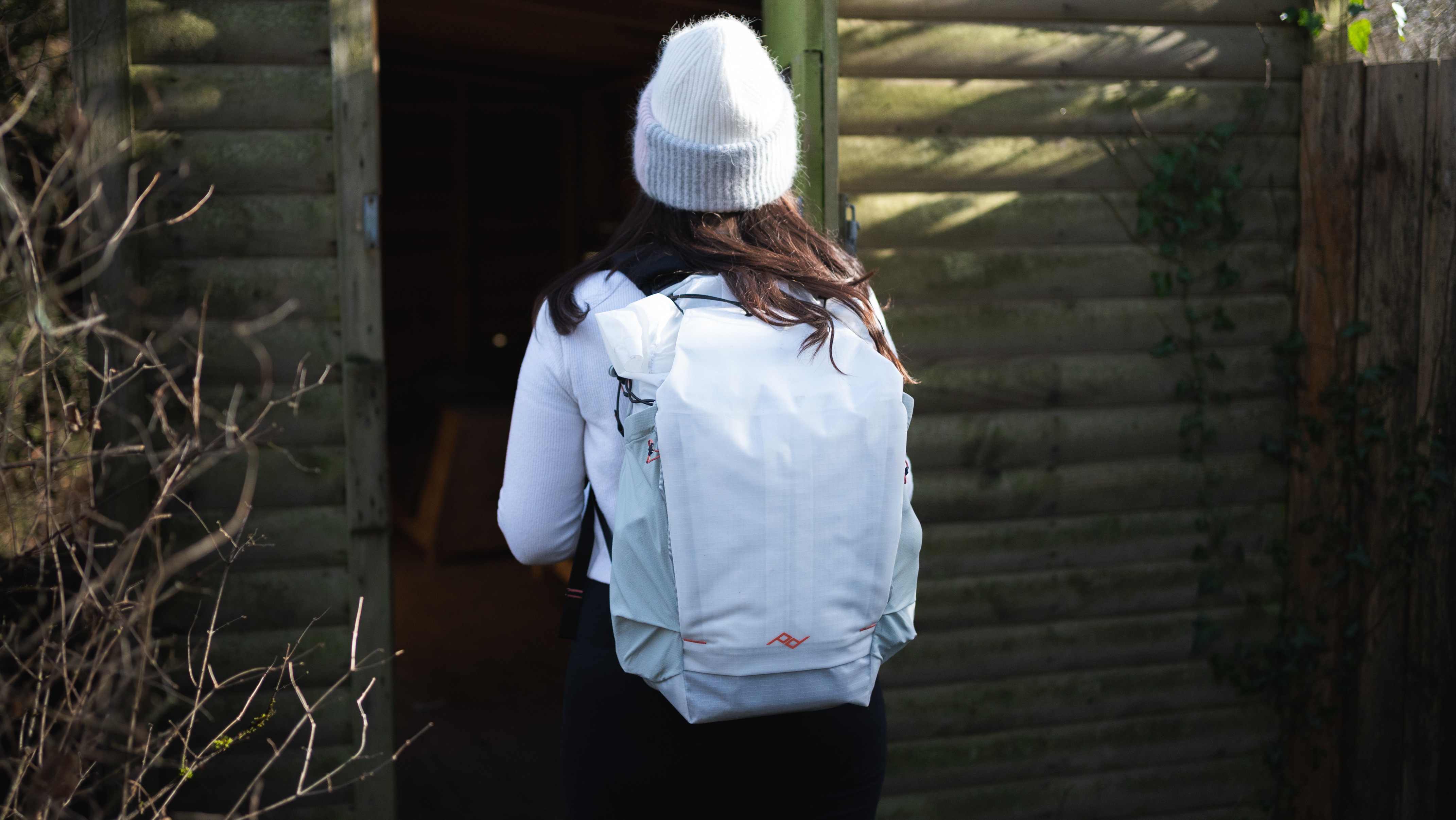 woman entering a hide while wearing the Peak Design outdoor backpack