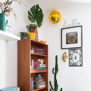 Corner of mid-century modern living room with golden disco ball and wooden bookcase