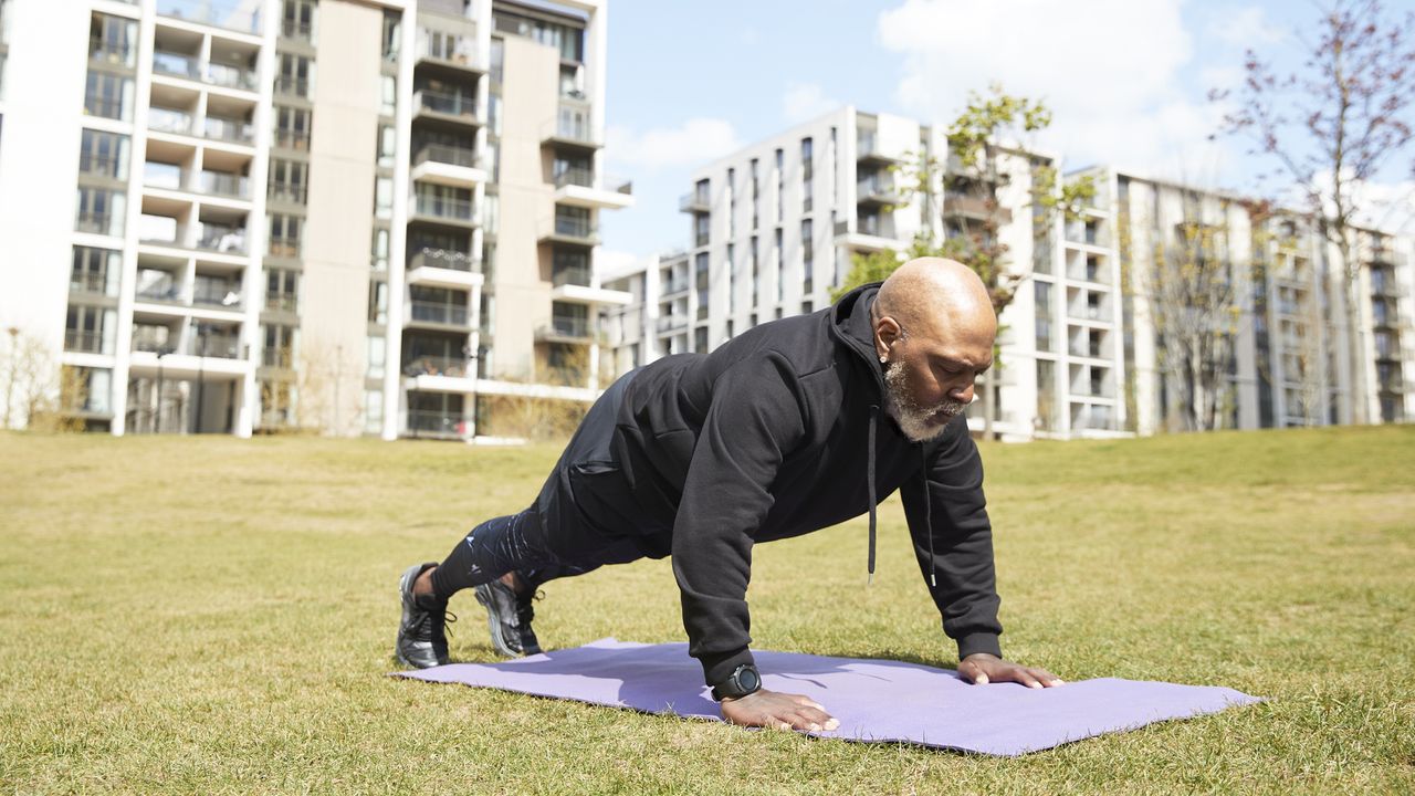 A man outdoors performing a plank