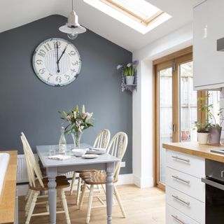 Dining area in kitchen extension with skylight, feature wall and large clock on the wall