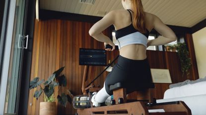 Ergatta vs Hydrow: woman exercising using an Ergatta rower