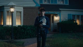 Teen holds a rabbit on a Westview street in Agatha All Along