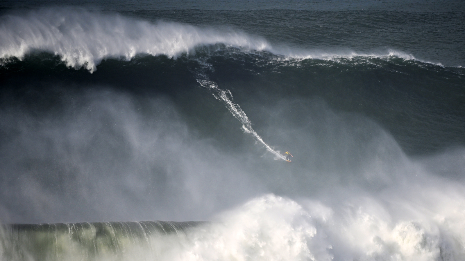 Photo of a surfer riding a giant wave