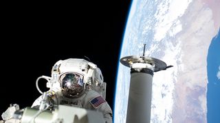 NASA spacewalker Josh Cassada prepares a roll-out solar array for its deployment.