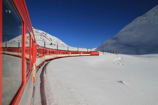 A train weaves through the snow on its way to Andermatt