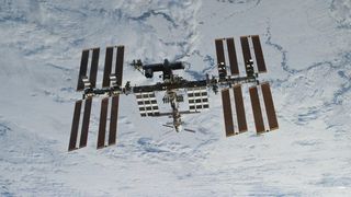 a view of the international space station and its solar panels in front of earth