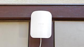 An Eero Outdoor 7 mesh extender mounted to an exterior wall