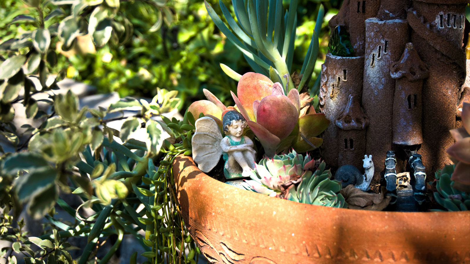 fairy garden container with fairy and plants