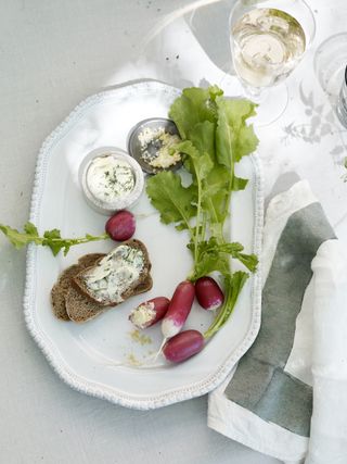 Freshly harvested radishes on a plate with bread and cheese