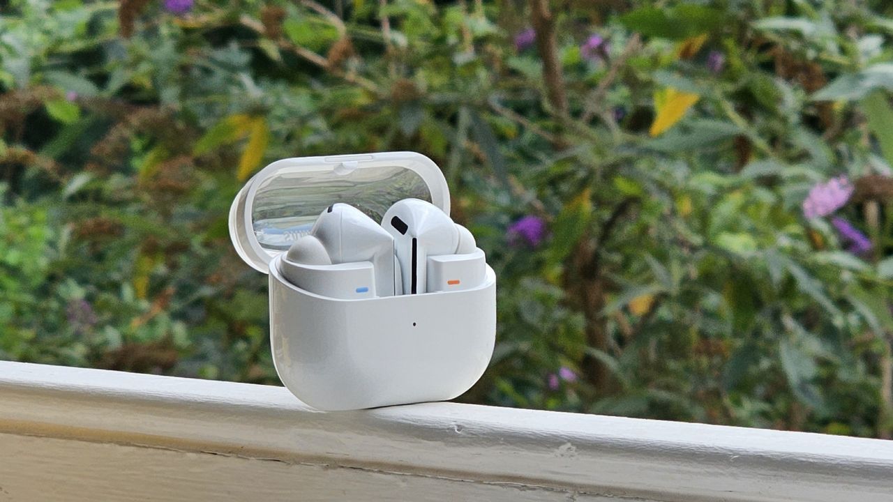 The Samsung Galaxy Buds 3 Pro against a leafy background.