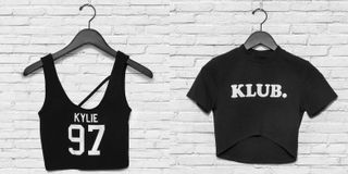 Two black tops hanging from a wall. One reads, "Kylie 97", while the other reads, "KLUB."