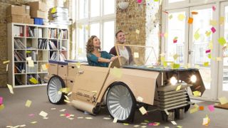 two people inside amazing cardboard car, with post-it note confetti