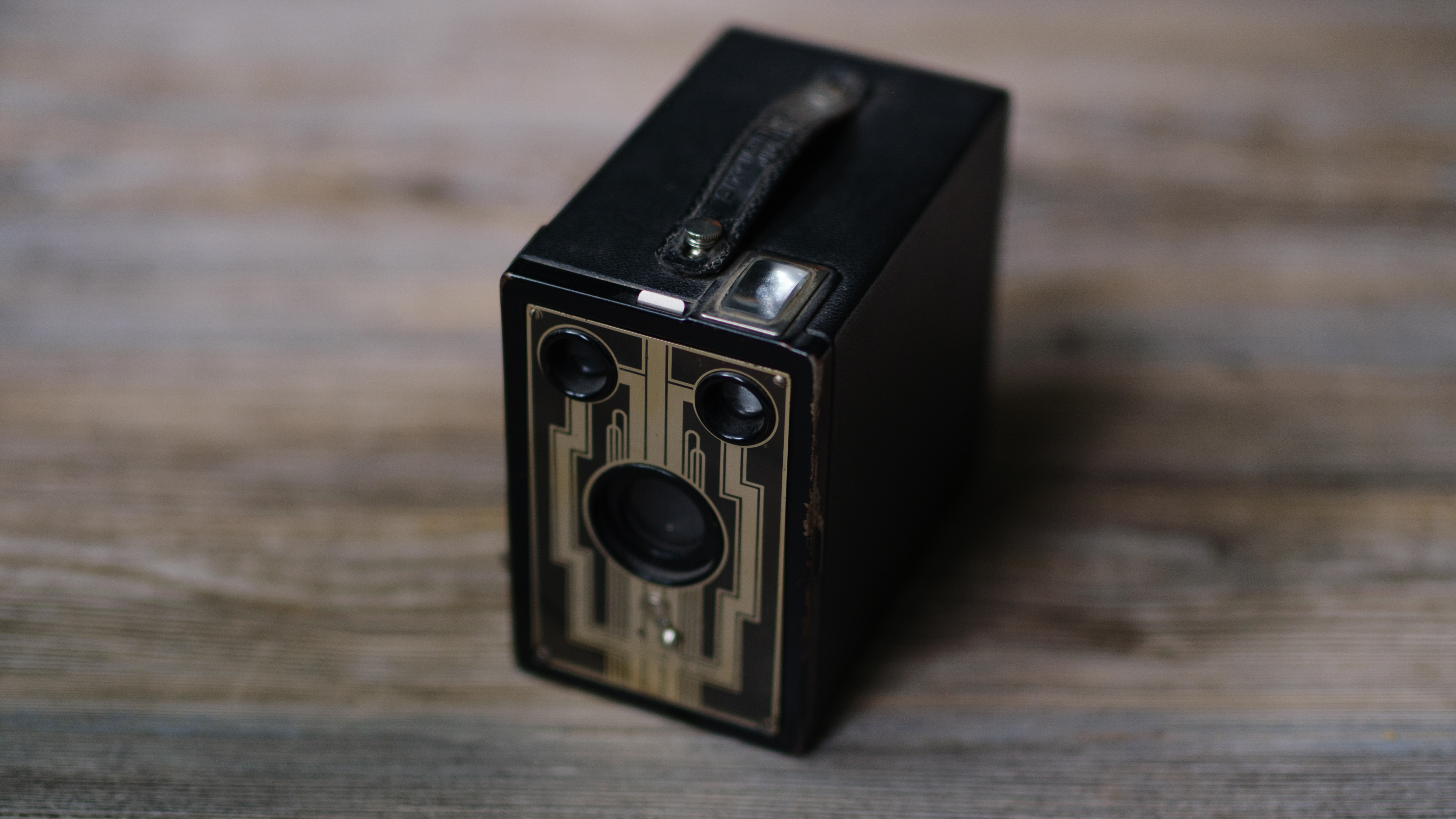 A photo of a vintage box camera taken under different lighting conditions