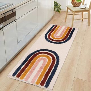 A cream runner rug with rainbows either side sits on a wooden kitchen floor
