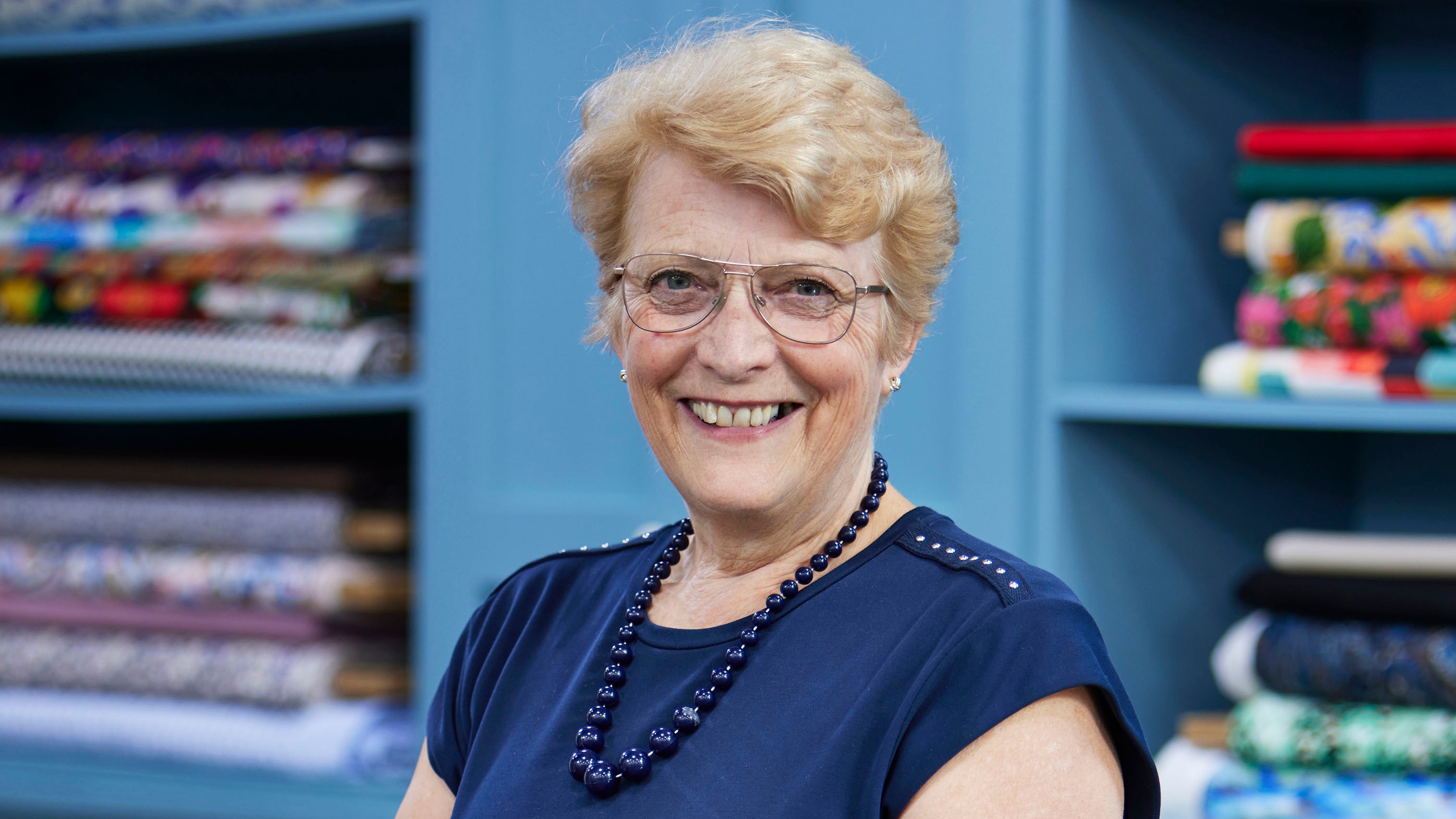 Gaynor standing in the Great British Sewing Bee studio and smiling for the camera