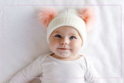 Cute adorable baby child with warm white and pink hat with cute bobbles - stock photo