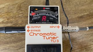 Boss TU-3 tuner on a wooden surface