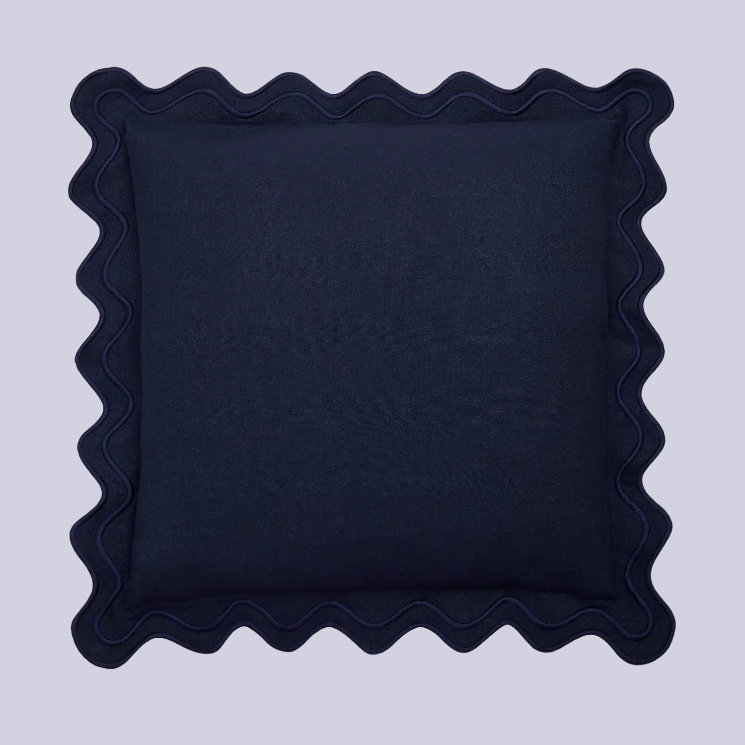 A dark blue pillow with a scalloped hem