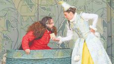 Woman in shakespearean costume shows man a piece of paper, with her hand on her hip