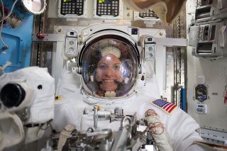 NASA astronaut Kate Rubins, seen here after a spacewalk during a previous stay on the International Space Station in 2016, identified a wire tie as the object she associates with the 20th anniversary of humans on the orbiting complex. The copper wire ties can be seen wrapped around the white hose in front of Rubins' left arm.