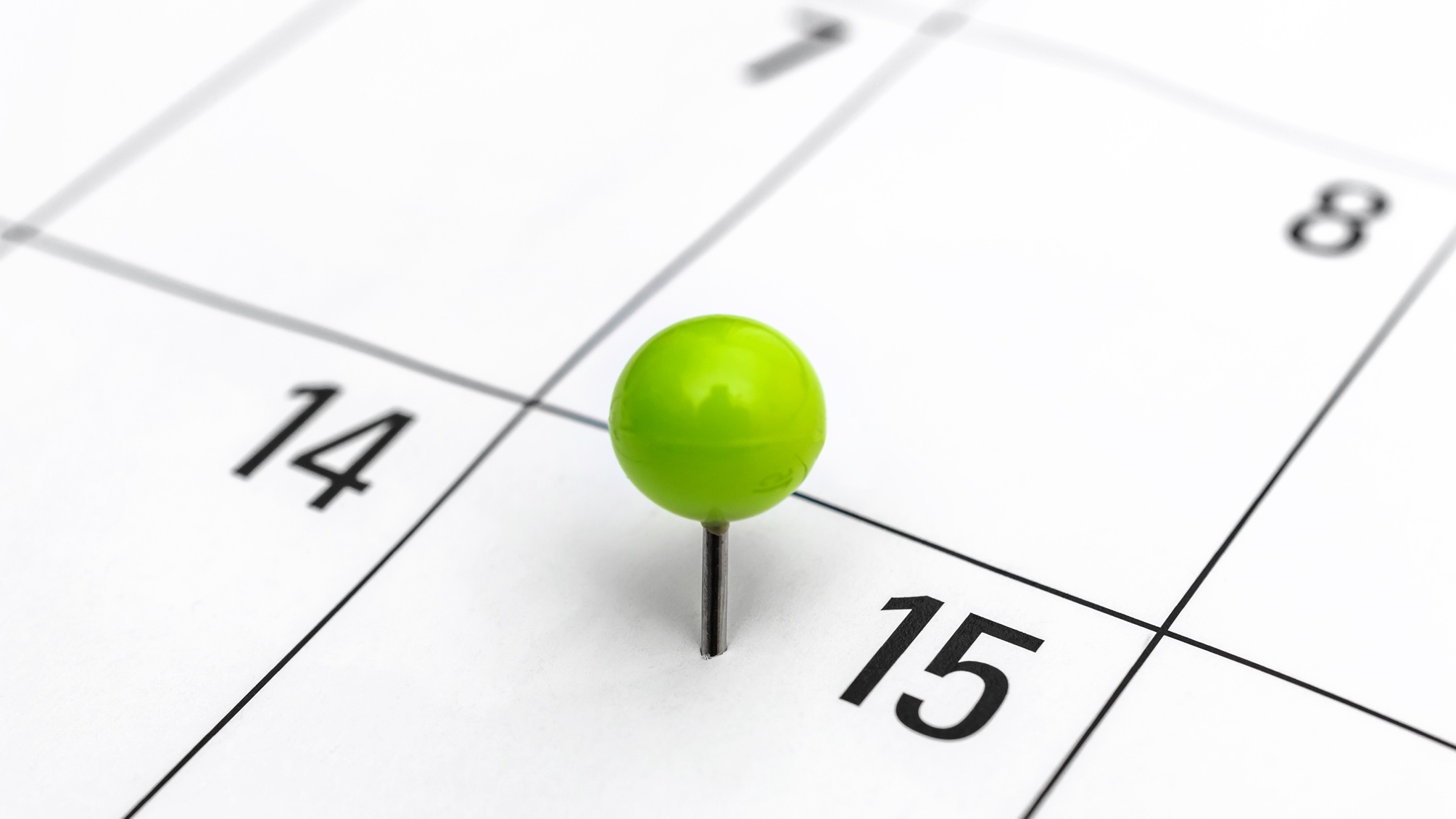 A green pushpin marks the 15th on a calendar.