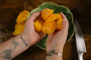 hands holding sliced tomato