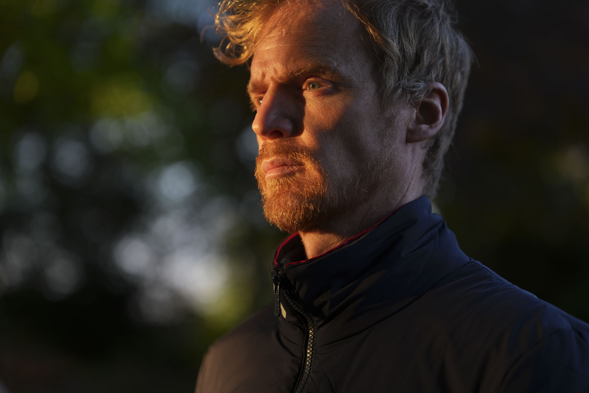 A man at golden hour, illuminated by the sun, natural background