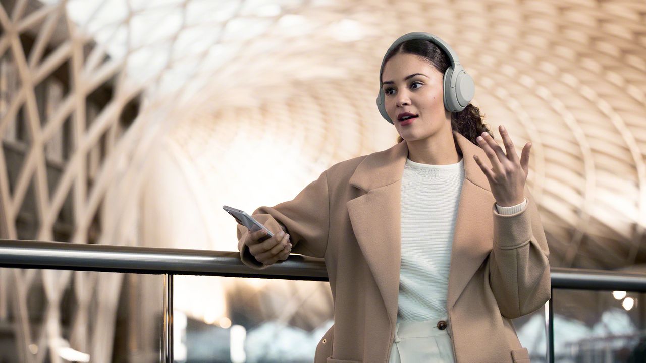 Wireless headphones worn by a women with an Android phone