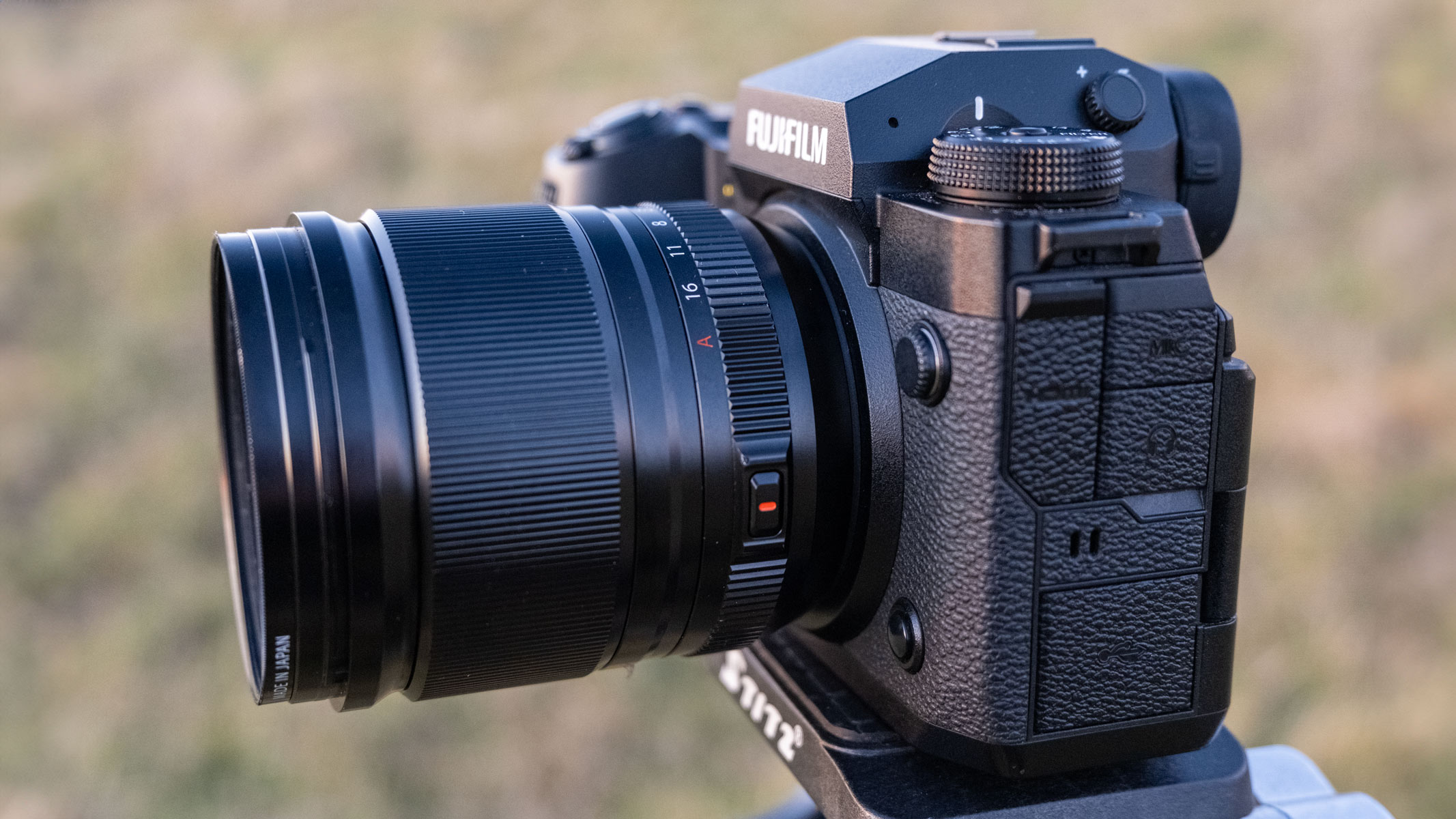 The Fujifilm X-H2 with Fujifilm XF 18mm f/1.4 lens on a tripod in a field.