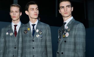 Three males modelling blazers with badges
