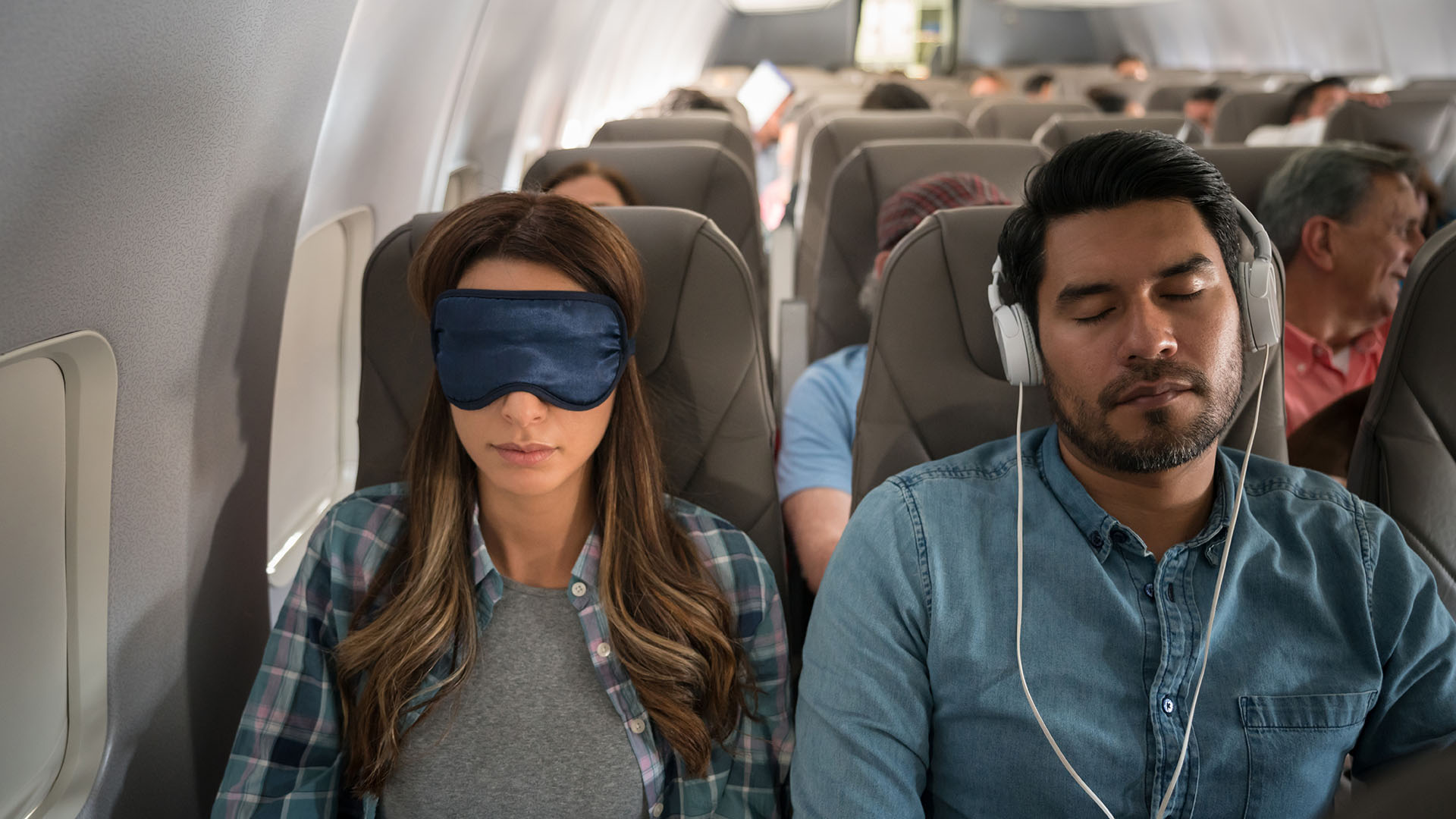 Мужчина и женщина спят в самолете